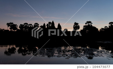 A dusk landscape in Cambodia, with the enigmatic outline of the Angkor Temple and its encompassing region slowly merging with the evening. 104473077