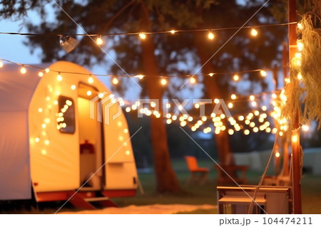 Blurred photo of camping tents with lighting decoration at night Blurred photo of camping tents with lighting decoration at night 104474211