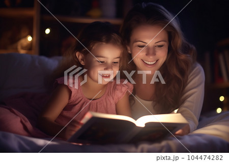 Family before going to bed mother reads to her child a book near a lamp in the evening Family before going to bed mother reads to her child a book near a lamp in the evening 104474282