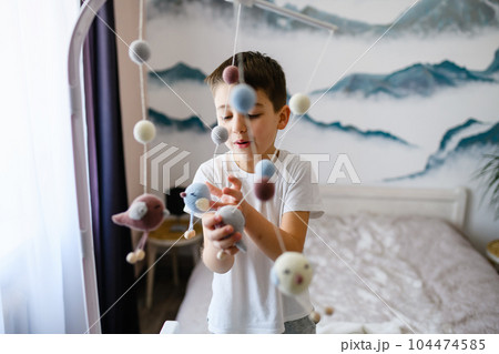 Older brother play with mobile newborn toys 104474585