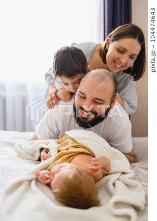 Happy family of four with newborn baby Happy family of four with newborn baby 104474643