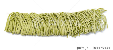 Raw spinach noodles on wheat flour on a white isolated background Raw spinach noodles on wheat flour on a white isolated background 104475434