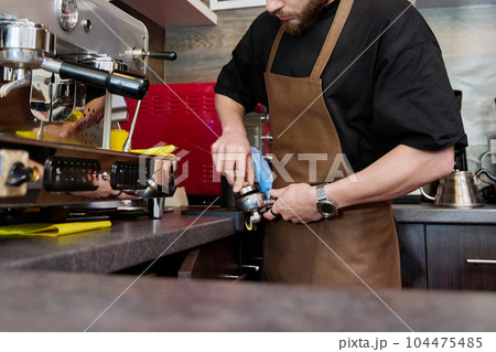 Young male barista preparing coffee in coffee shop 104475485