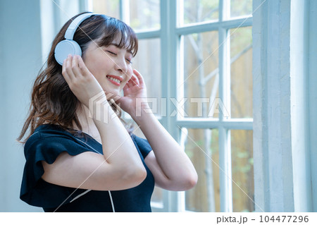 ヘッドホンで音楽を聴く若い女性 ヘッドホンで音楽を聴く若い女性 104477296