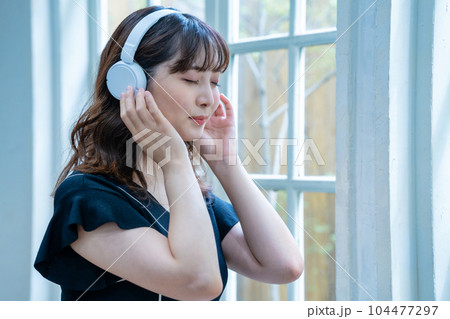 ヘッドホンで音楽を聴く若い女性 ヘッドホンで音楽を聴く若い女性 104477297