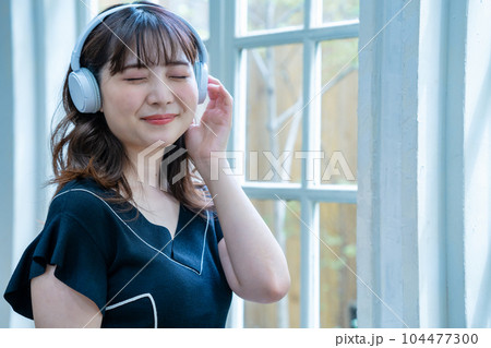 ヘッドホンで音楽を聴く若い女性 ヘッドホンで音楽を聴く若い女性 104477300