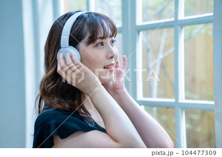 ヘッドホンで音楽を聴く若い女性 ヘッドホンで音楽を聴く若い女性 104477309