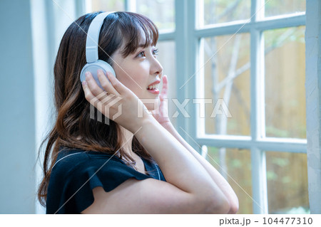 ヘッドホンで音楽を聴く若い女性 ヘッドホンで音楽を聴く若い女性 104477310
