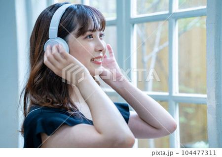 ヘッドホンで音楽を聴く若い女性 ヘッドホンで音楽を聴く若い女性 104477311