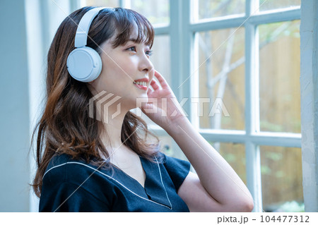 ヘッドホンで音楽を聴く若い女性 ヘッドホンで音楽を聴く若い女性 104477312