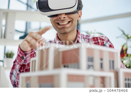 Virtual reality futuristic design technology. Architect or design engineer in VR headset for BIM technology designing a 3D model Virtual reality futuristic design technology. Architect or design engineer in VR headset for BIM technology designing a 3D model 104478408