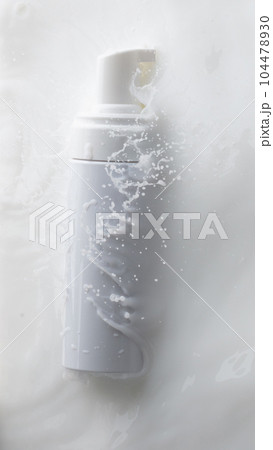 Cosmetic container white lotion droplet fly splashing. Milk lotion pour float to cosmetic bottle. Moisturizer lotion explosion spill. White background isolated high speed shutter freeze top view Cosmetic container white lotion droplet fly splashing. Milk lotion pour float to cosmetic bottle. Moisturizer lotion explosion spill. White background isolated high speed shutter freeze top view 104478930