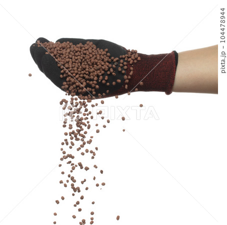 Clay Drainage tiny size ball pour fall down, explosion in shovel hand. Clay Drainage ball splash in shape form line explosion. White background isolated high speed shutter freeze motion 104478944