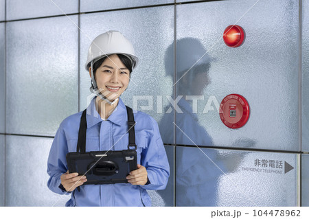 火災報知器の点検をする作業服の女性 ビルメンテナンス イメージ 火災報知器の点検をする作業服の女性 ビルメンテナンス イメージ 104478962