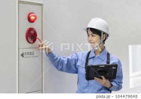 火災報知器の点検をする作業服の女性　ビルメンテナンス　イメージ 104479048