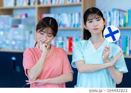 NGプレートを出す二人の看護師の女性 104482822