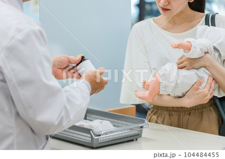 薬局に来た困っている産後のママ・母親と服薬指導する薬剤師（妊婦・授乳婦薬物療法認定薬剤師） 104484455
