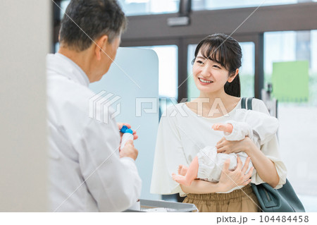 薬局に来た産後のママ・母親と服薬指導する薬剤師（妊婦・授乳婦薬物療法認定薬剤師） 104484458