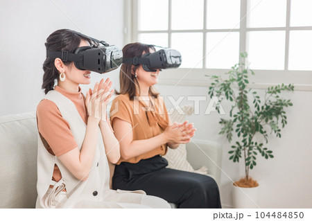 家で擬似旅行・VRゲーム・3D映画を楽しむVRゴーグルをつけた女性たち 104484850
