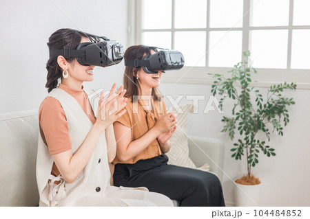 家でVRゲーム・ライブ鑑賞・3D映画を楽しむVRゴーグルをつけた女性たち 104484852
