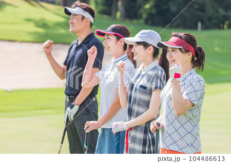 ゴルフ場でゴルフを楽しむゴルファーの男女 104486613