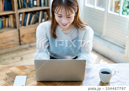 部屋でノートパソコンを使う若い女性 部屋でノートパソコンを使う若い女性 104487797