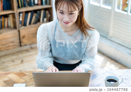 部屋でノートパソコンを使う若い女性 104487798