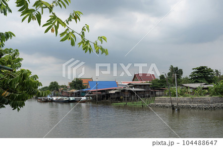 A traditional old house by the river with boats passing by. on creativity 104488647
