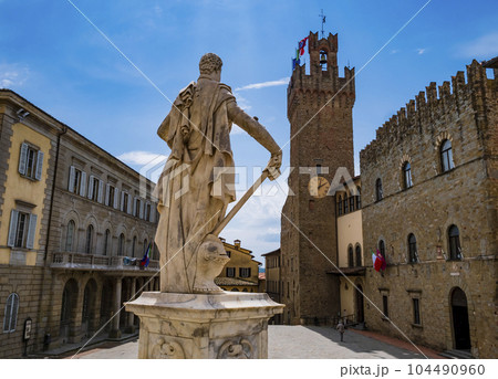 Arezzo, impressive view of Piazza Duomo and its historical buildings with Ferdinando de Medici statue in foreground, Tuscany, Italy 104490960