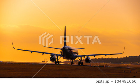 美しい夕焼け空と離陸する飛行機風景　(阿蘇くまもと空港) 104491060