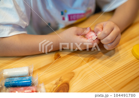 女の子がカラフルな紙粘土で遊ぶ 女の子がカラフルな紙粘土で遊ぶ 104491780