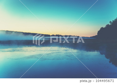 The magical foggy sunrise over the lake. Rural landscape. Summer landscape in the early morning The magical foggy sunrise over the lake. Rural landscape. Summer landscape in the early morning 104495671