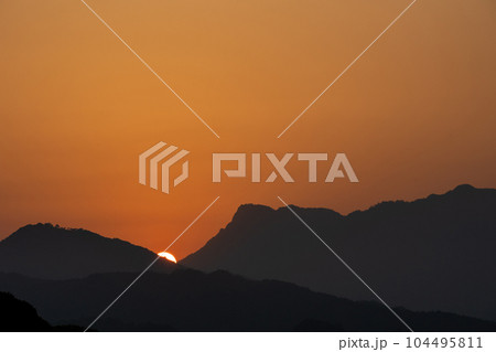 山に沈みゆく夕陽 104495811