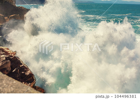 A huge wave is breaking on the rocks. Splash of the wave. Rocky seashore. Beautiful nature, landscape, stormy sea. San Sebastian, Basque Country, Spain, Europe A huge wave is breaking on the rocks. Splash of the wave. Rocky seashore. Beautiful nature, landscape, stormy sea. San Sebastian, Basque Country, Spain, Europe 104496381