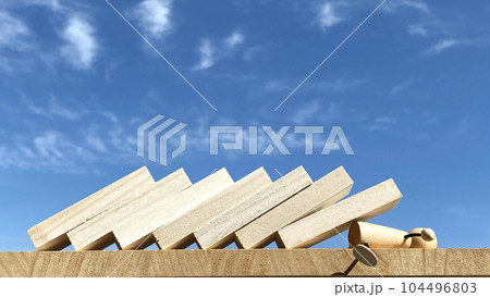 倒れるたくさんの板に押しつぶされる人形 104496803