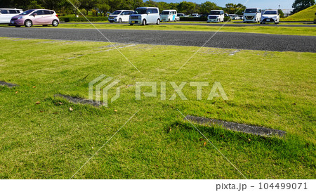 芝生の駐車場に止めた車両 104499071
