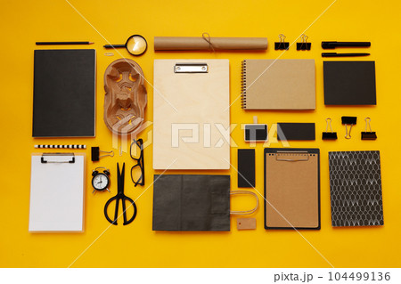 Mockup flat lay with different office accessories on yellow background Mockup flat lay with different office accessories on yellow background 104499136