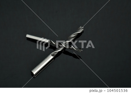 Two drills for working with wood lie on a dark background. Two drills for working with wood lie on a dark background. 104501536