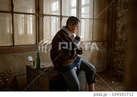 Portrait of young frustrated homeless woman smoking cigarette 104501712