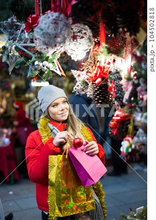 Girl choosing Christmas gifts outdoor on street market Girl choosing Christmas gifts outdoor on street market 104502818