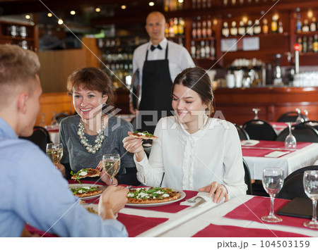 Two girls with male friend in restaurant 104503159