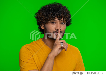 Young indian man presses finger to lips makes silence gesture sign do not tells secret, stop gossip Young indian man presses finger to lips makes silence gesture sign do not tells secret, stop gossip 104503187