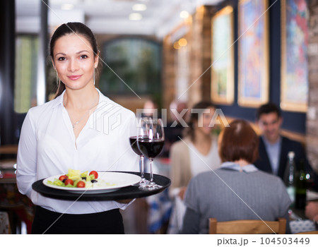 Waitress standing in restaurant Waitress standing in restaurant 104503449