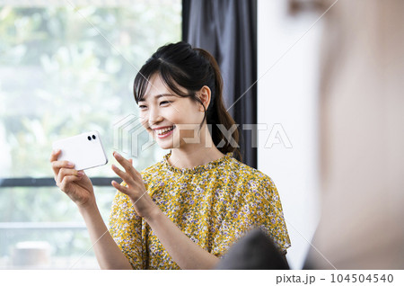 笑顔でスマホを見る若い女性 104504540