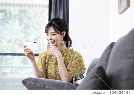 笑顔でスマホを見る若い女性 104504544