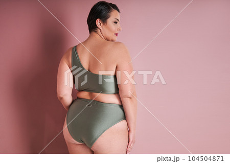 Curvy smiling asian woman in underwear standing over pink studio background Curvy smiling asian woman in underwear standing over pink studio background 104504871