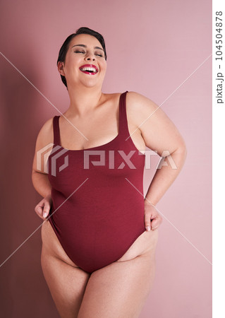 Happy chubby korean woman laughing at red studio background Happy chubby korean woman laughing at red studio background 104504878