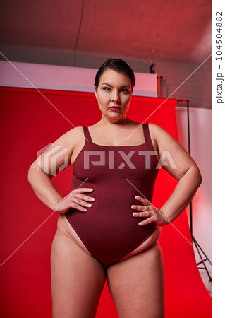 Vertical view of the confident body positive asian woman looking at the camera Vertical view of the confident body positive asian woman looking at the camera 104504882