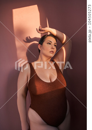 Body positive woman in underwear standing over pink studio background 104505273