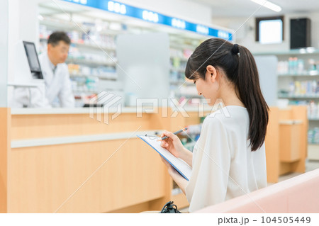 病院・薬局の待合室で問診票を書く女性 104505449